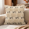 A beige plush throw pillow cover featuring a repeating pattern of black pumpkins and maple leaves.