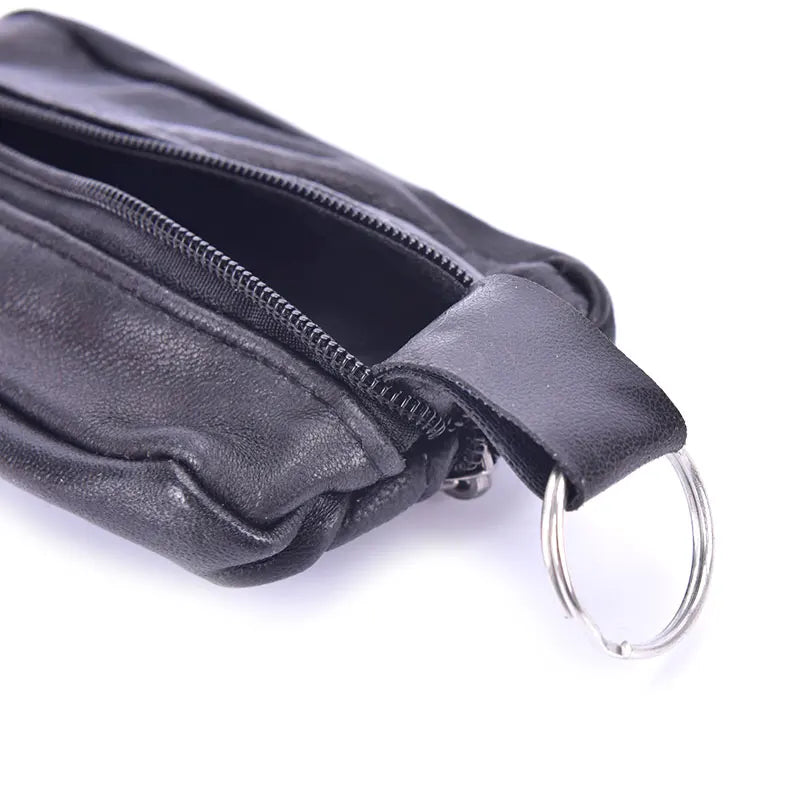A black leather compact zippered coin purse with a key holder attached.