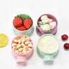 Pink and green bear-shaped baby food storage containers filled with various fruit and vegetable purees