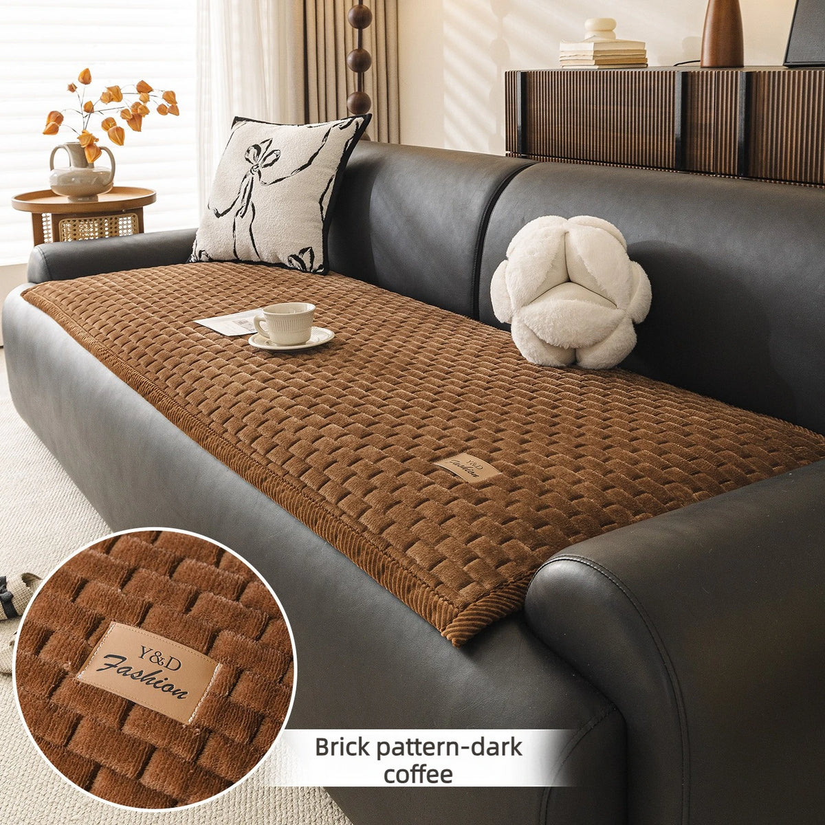 Dark brown quilted fabric sofa cover with a textured pattern and a plush white decorative pillow.