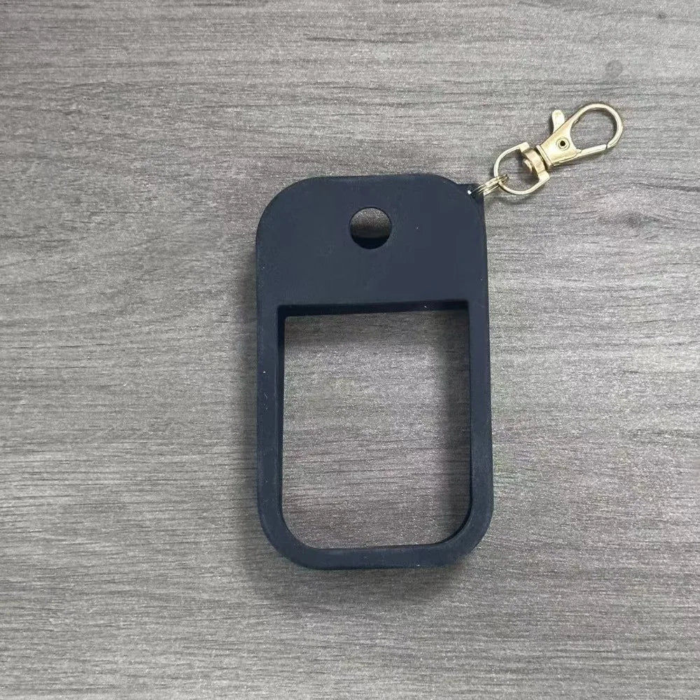 Black silicone protective case for a hand sanitizer spray attached to a gold keyring