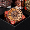 A close-up of a premium metal spinner dice cube with a dragon design, resting in a black gift box.