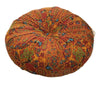 A round, textured floor cushion in a vibrant orange and rust pattern with blue accents.
