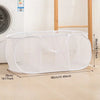 White folding mesh laundry basket with comfortable handles shown on a wooden floor.