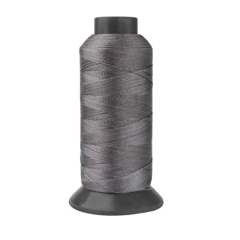 A spool of gray heavy-duty nylon sewing thread for upholstery and denim.