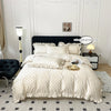 A beige duvet cover set with black polka dots and ruffled edges displayed on a bed.
