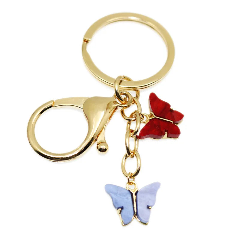 Gold hoop keychain charm featuring a red butterfly and a blue butterfly.