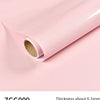 Roll of pink glitter peel-and-stick vinyl contact paper shown rolled up on a light pink surface