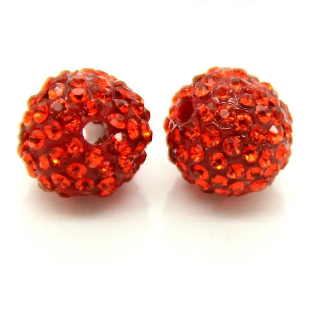 A pair of round, faceted, orange-red crystal clay beads for DIY jewelry and craft projects.