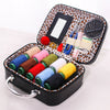 Portable faux leather sewing kit organizer with various colored threads and needles in a zippered case.