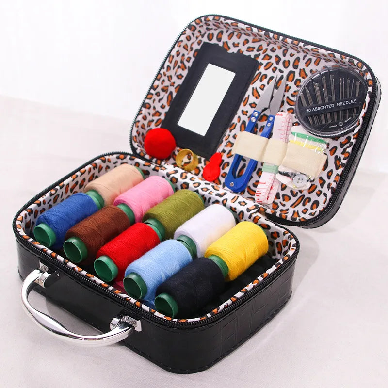 Portable faux leather sewing kit organizer with various colored threads and needles in a zippered case.