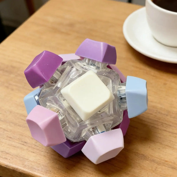 A small, clear fidget toy with purple and blue hexagonal pieces rests on a wooden table.