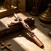 A bronze crucifix pen set featuring an INRI Jesus cross writing instrument resting on a leather-bound book.