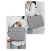 A woman is shown carrying a gray waterproof nylon laptop sleeve for notebooks on her shoulder.
