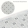Close-up view of a white non-slip mat with a black dot design on the bottom surface.