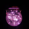 A glowing purple crackle glass solar lantern illuminating a spherical shape against a dark background.