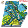 Blue and green African wax print fabric featuring abstract patterns on a textile roll.