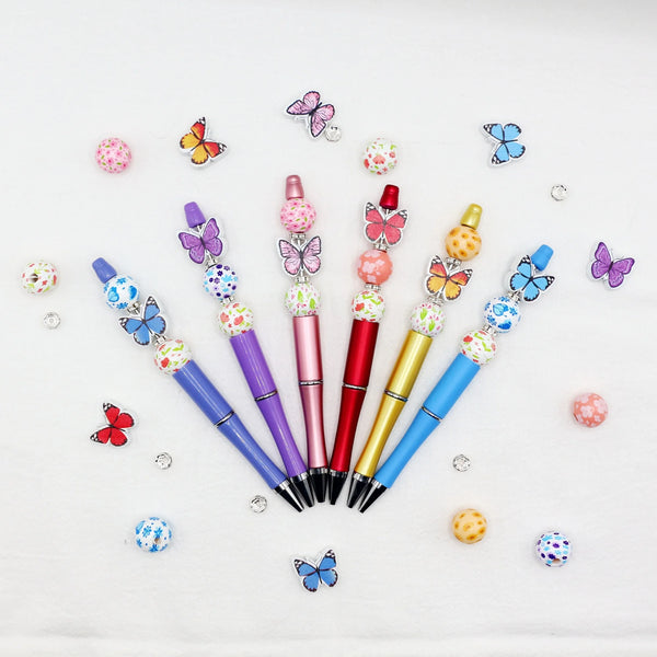 Set aus Regenbogen-Schmetterlings- und Blumen-Perlen-Ballpunkten mit bunten Akzenten auf weißem Untergrund.