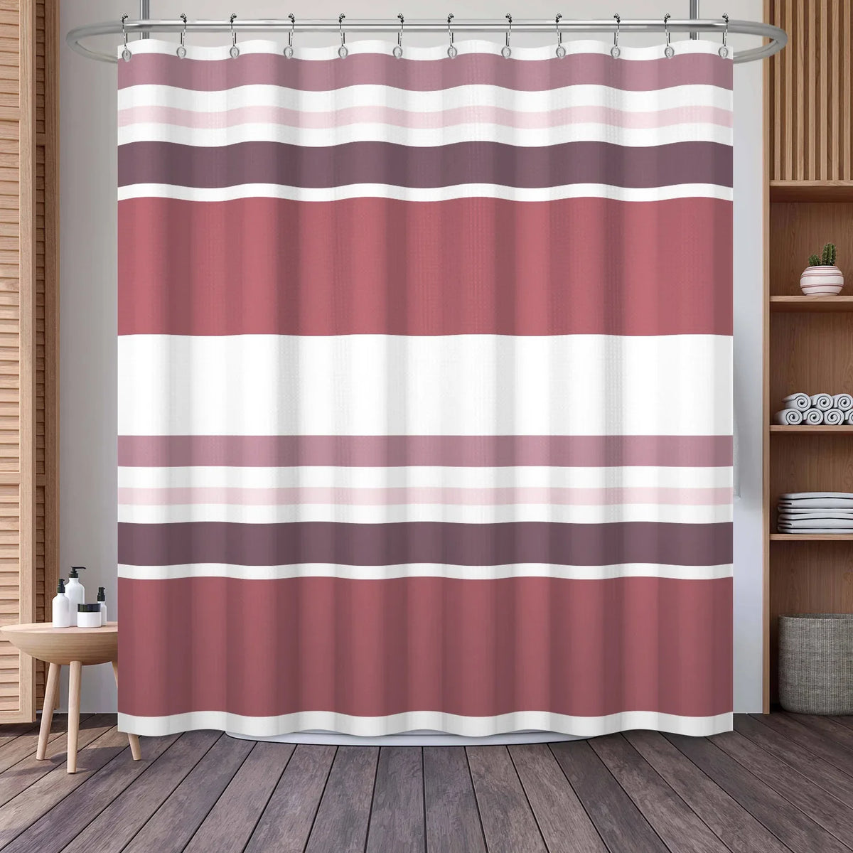 A shower curtain featuring a vertical geometric stripe pattern in shades of pink, mauve, and white.