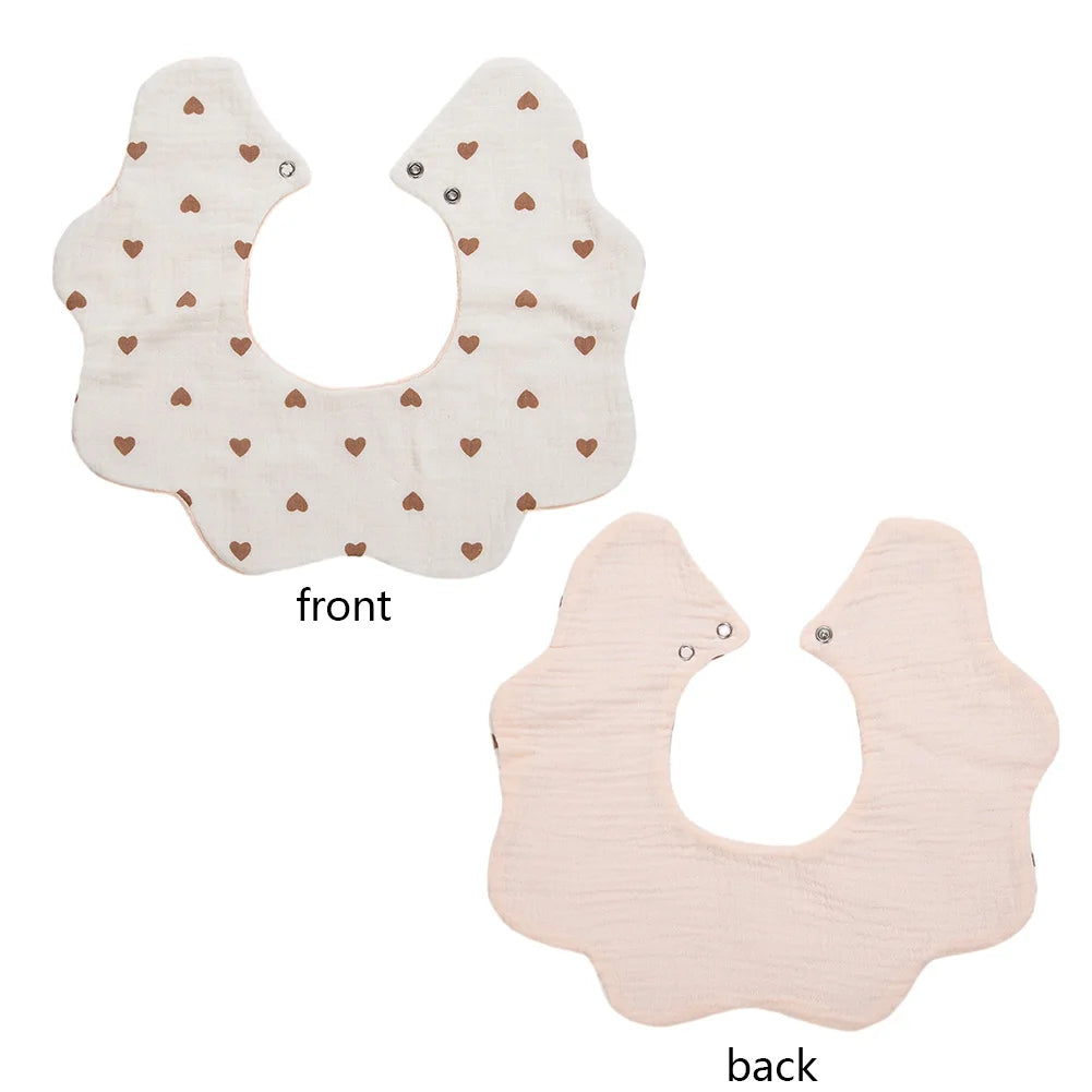 Front and back views of a light pink muslin cotton baby bib or burp cloth with an adjustable snap closure.