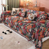A romantic floral jacquard sofa blanket featuring rich colors and tassels draped over a sofa.