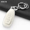 Silver key fob cover with a pendant attached to a black leather wallet.