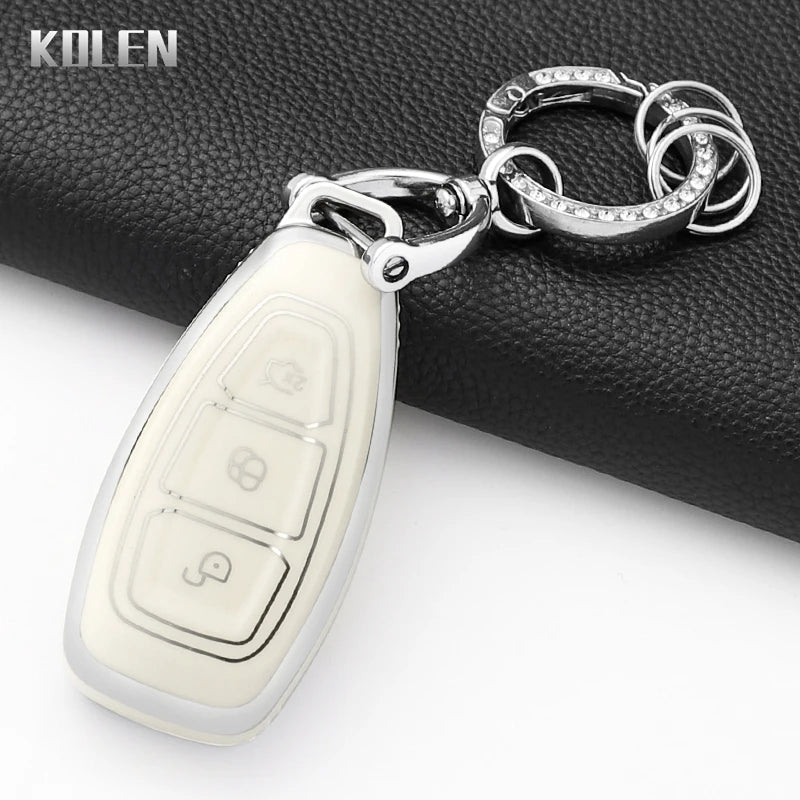 Silver key fob cover with a pendant attached to a black leather wallet.
