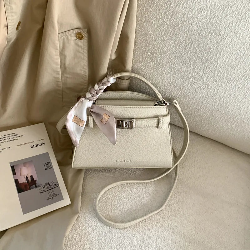 Beige eleganter PU-Leder-Clutchtasche mit geflochtenem Riemchen auf hellem Stoff.