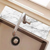 A stainless steel faucet is mounted on a marble countertop, with a circular drying mat visible below.