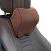 A brown memory foam car headrest neck pillow with an adjustable strap is shown on a gray car seat.