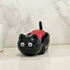 A black cat-shaped soap box with a red drainage tray sits on a white countertop.