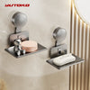 A silver wall-mounted soap dish with a suction cup holder and drain is installed on a beige wall.