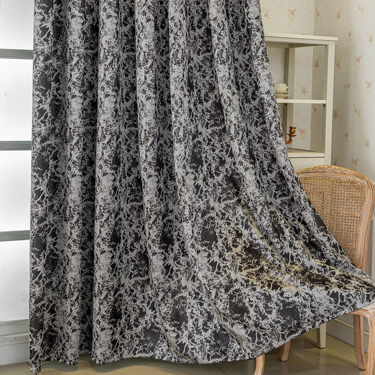 A black and white tree bark jacquard blackout curtain panel hanging in a light-colored room.