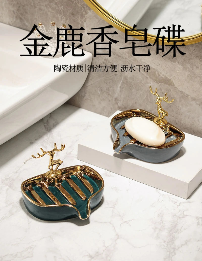 A golden leaf-shaped ceramic soap dish with a drain rack is displayed on a white marble surface.