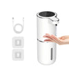 A white touchless automatic soap dispenser with a black lid and USB charging cable shown next to a hand.