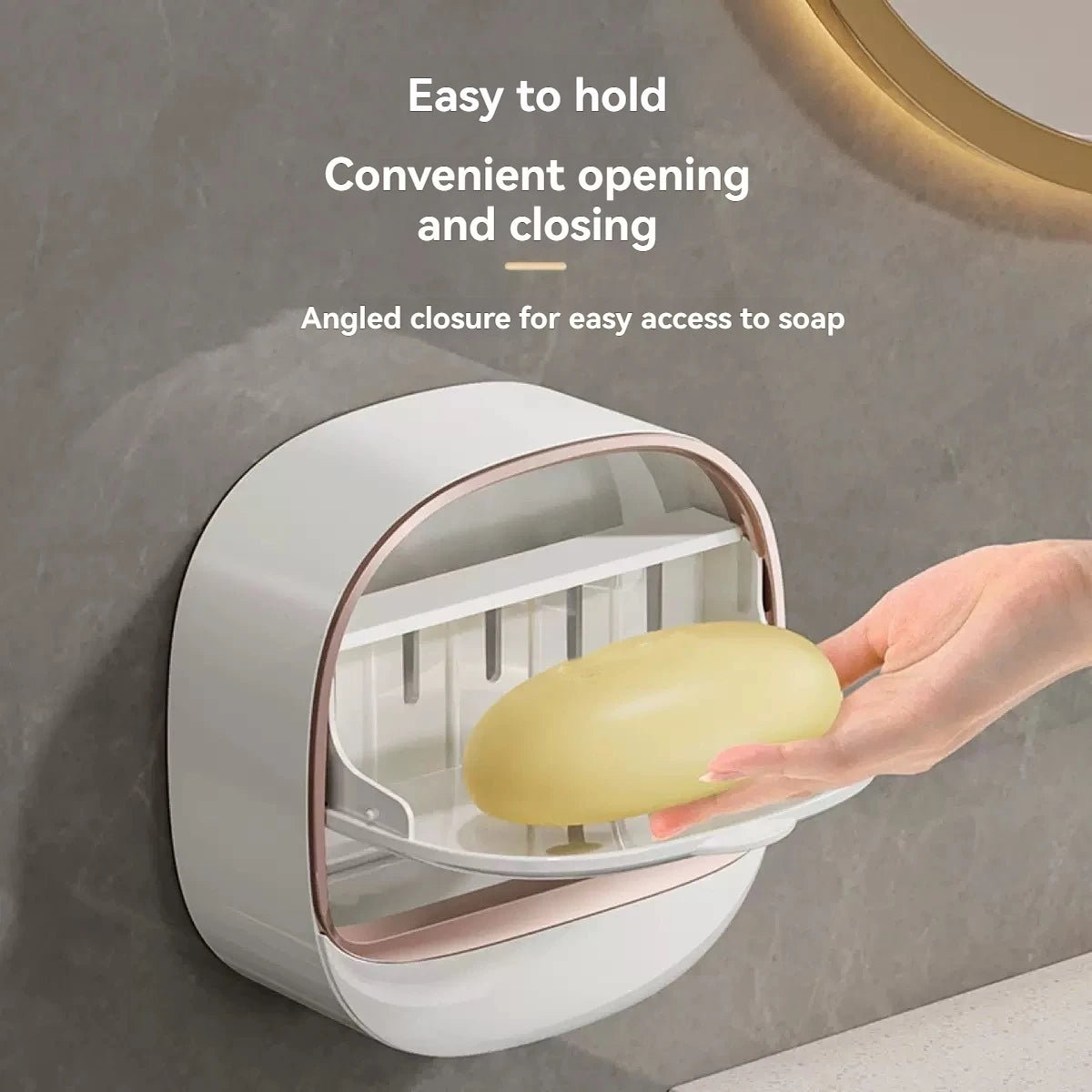 A hand is holding a white hanging soap holder with an angled closure for easy access to soap.