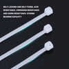 Three white nylon self-locking cable ties with plastic fixing mechanisms shown against a dark background.