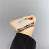 A hand holds an iPhone in a clear glow-in-the-dark neon case against a light gray background.