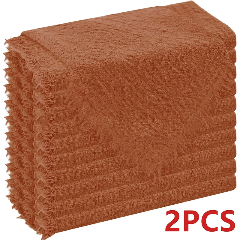 A stack of six rust-colored, raw-edge polyester cloth napkins.