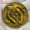 Runde goldene Münze mit detailliertem chinesischem Koi-Fischdesign, wahrscheinlich als Glücksgabe verwendet.