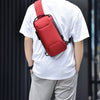 Un hombre lleva una bolsa cruzada roja en una camiseta blanca.