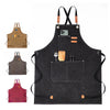 A black canvas apron with leather straps and pockets, featuring a large front pocket and small accessories.