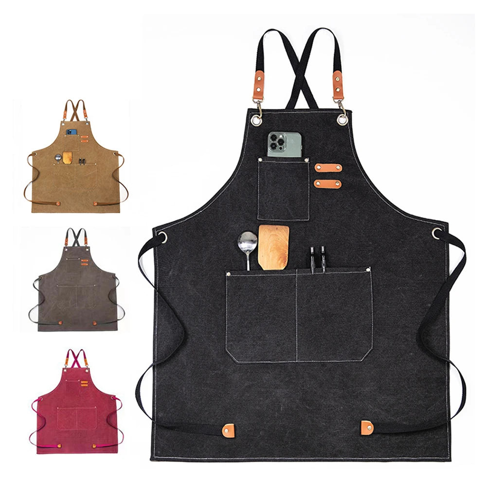A black canvas apron with leather straps and pockets, featuring a large front pocket and small accessories.