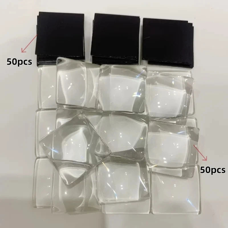A collection of clear glass cabochons and black magnets for a dome magnet making kit.