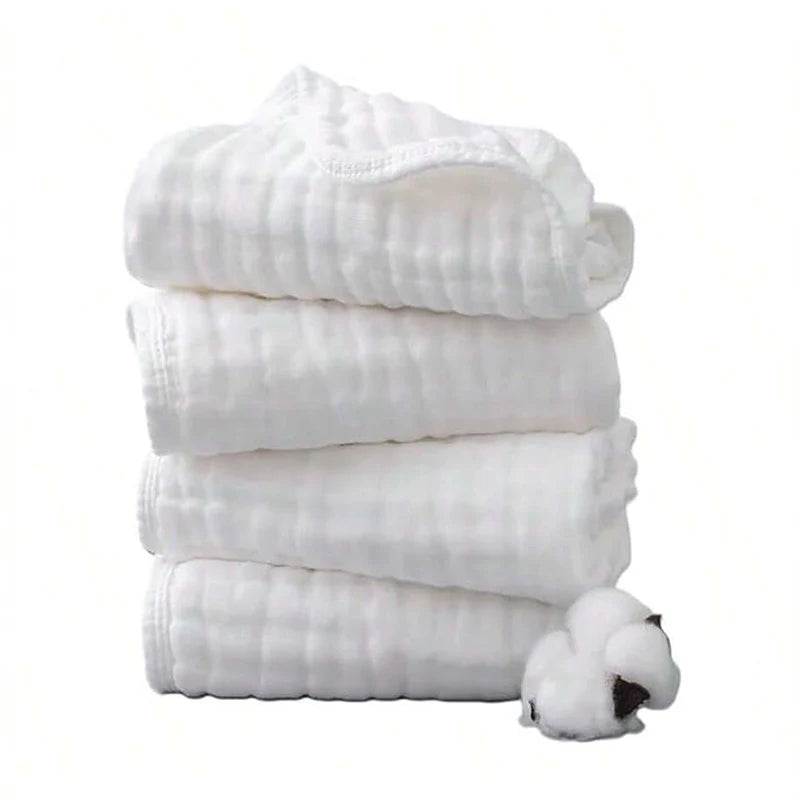 A stack of three white extra soft muslin burp cloths with a small white animal attached.