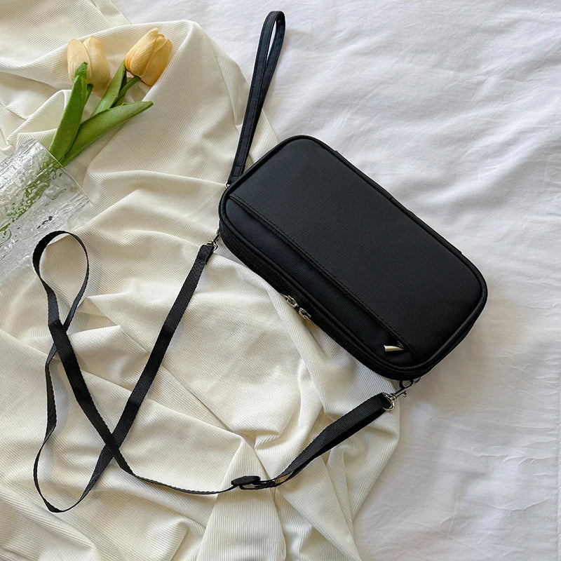 A black waterproof family passport and document organizer wallet is displayed on a white fabric with yellow tulips.