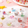 A collection of ten glitter resin duck figurines scattered on pink snow-like powder.