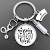 Silver necklace keychain featuring a glass dome pendant with the text Nursing is a work of heart