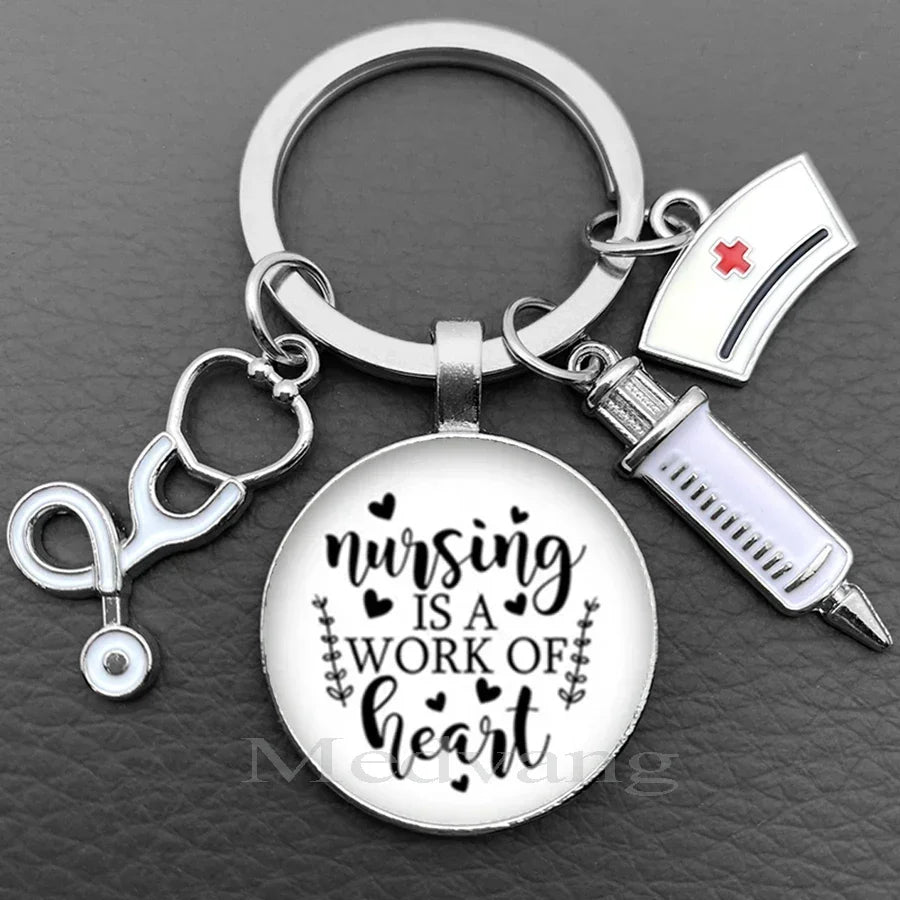Silver necklace keychain featuring a glass dome pendant with the text Nursing is a work of heart