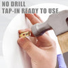 Eine Hand hält einen goldfarbenen Tap-in-Anker neben einem Hammer, der sofort einsatzbereite Produkt demonstriert.